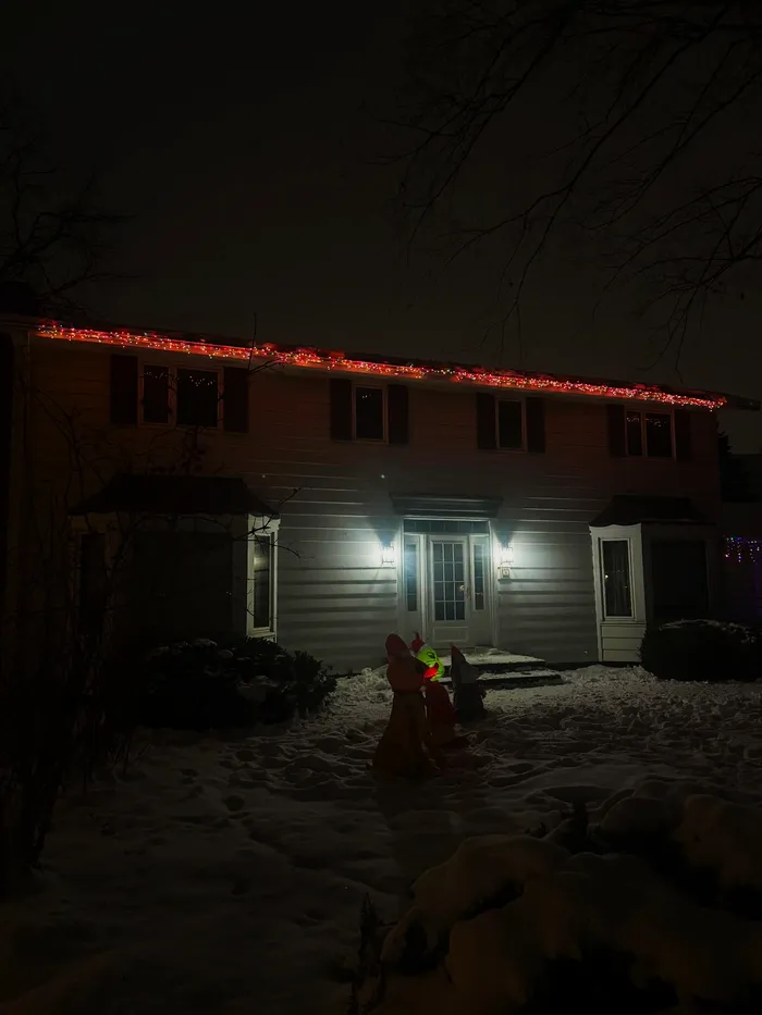 Christmas lights tracing a snowy roofline